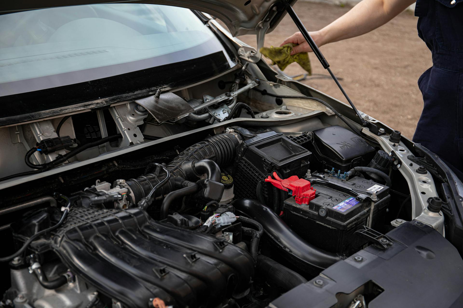 ASE certified mechanic replacing starter motor on vehicle outdoors in Oklahoma City