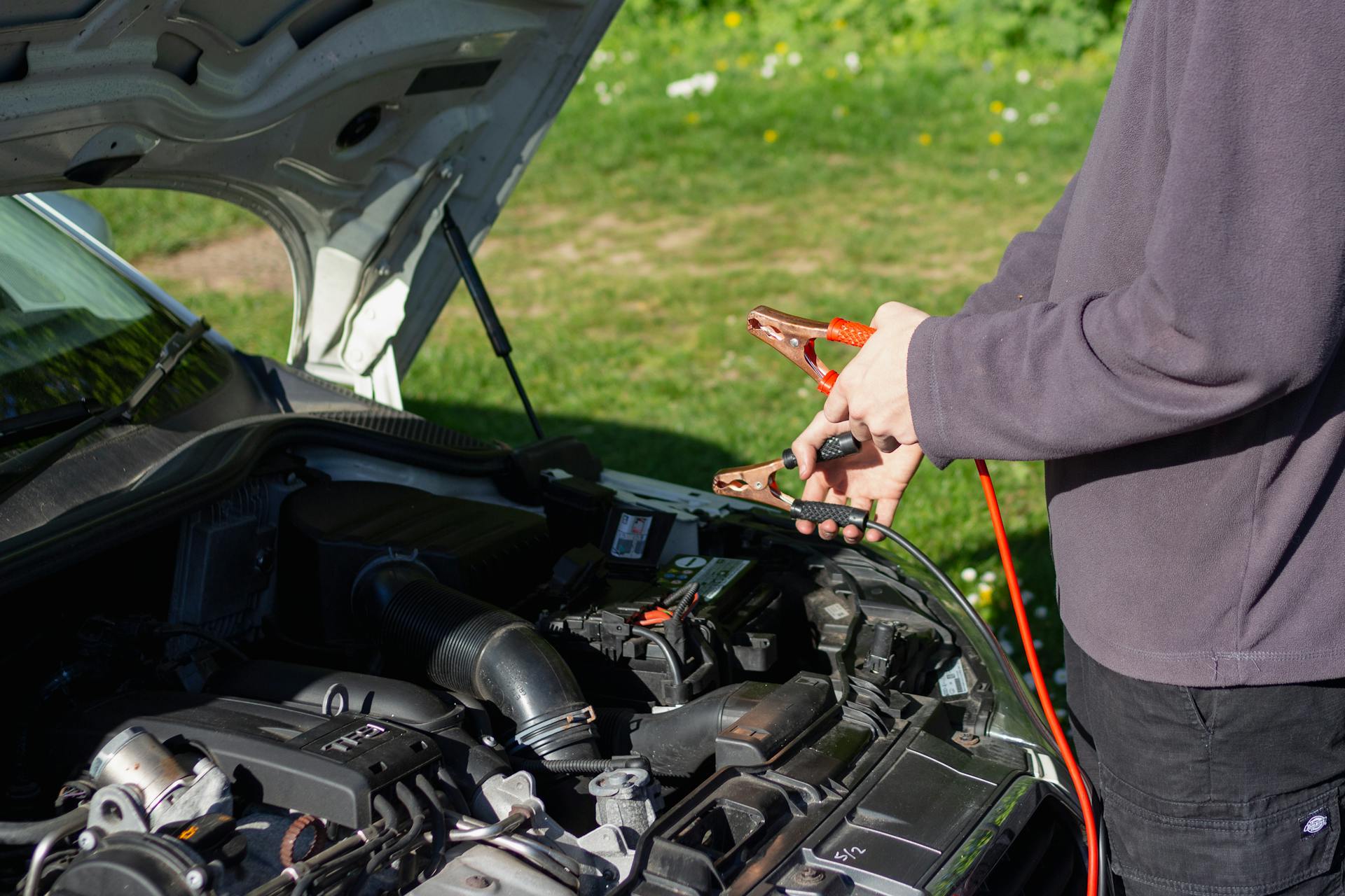 Mechanic performing mobile car battery replacement outdoors in Oklahoma City driveway