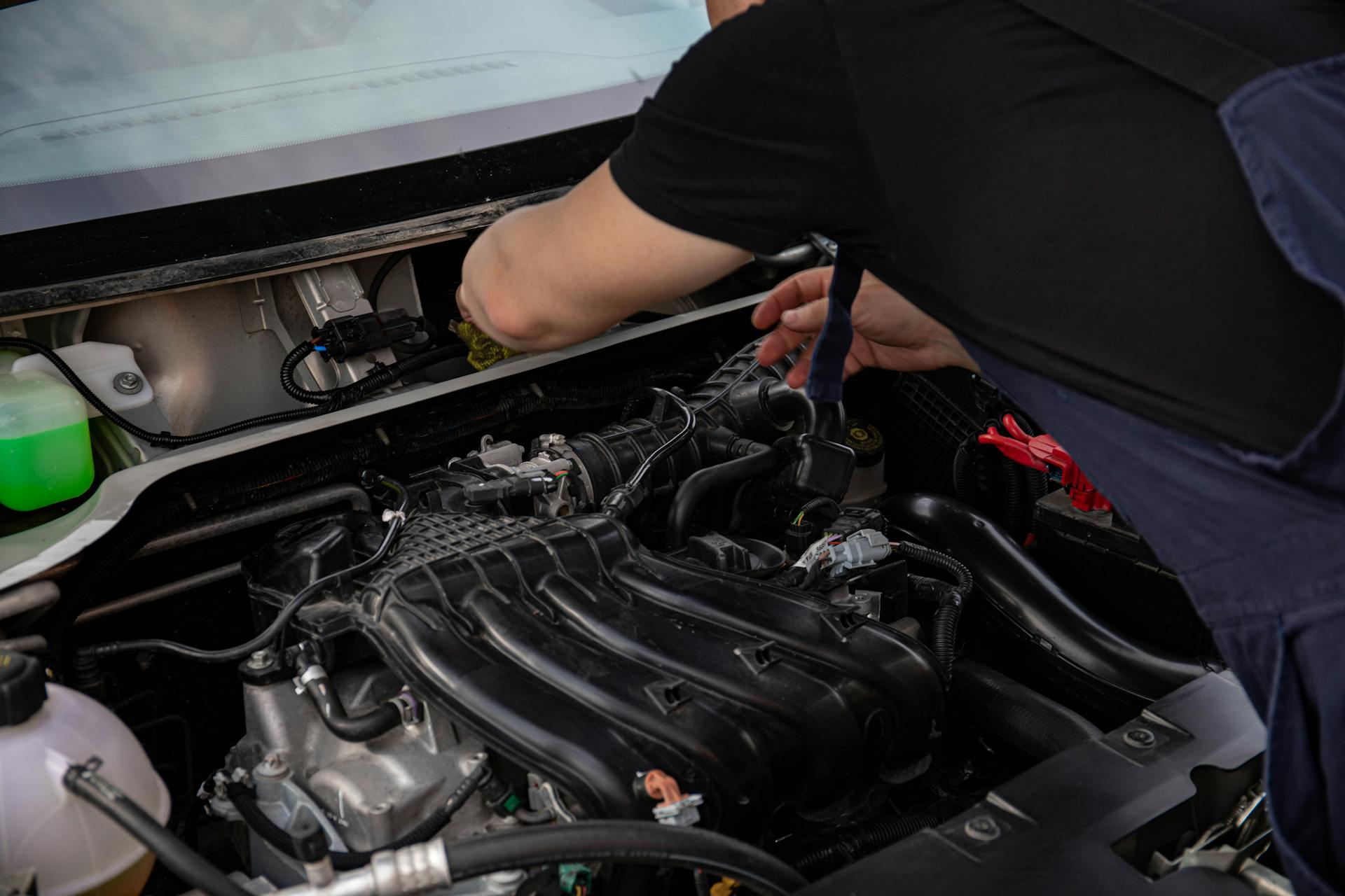 Mechanic replacing serpentine belt on vehicle outdoors in Oklahoma City