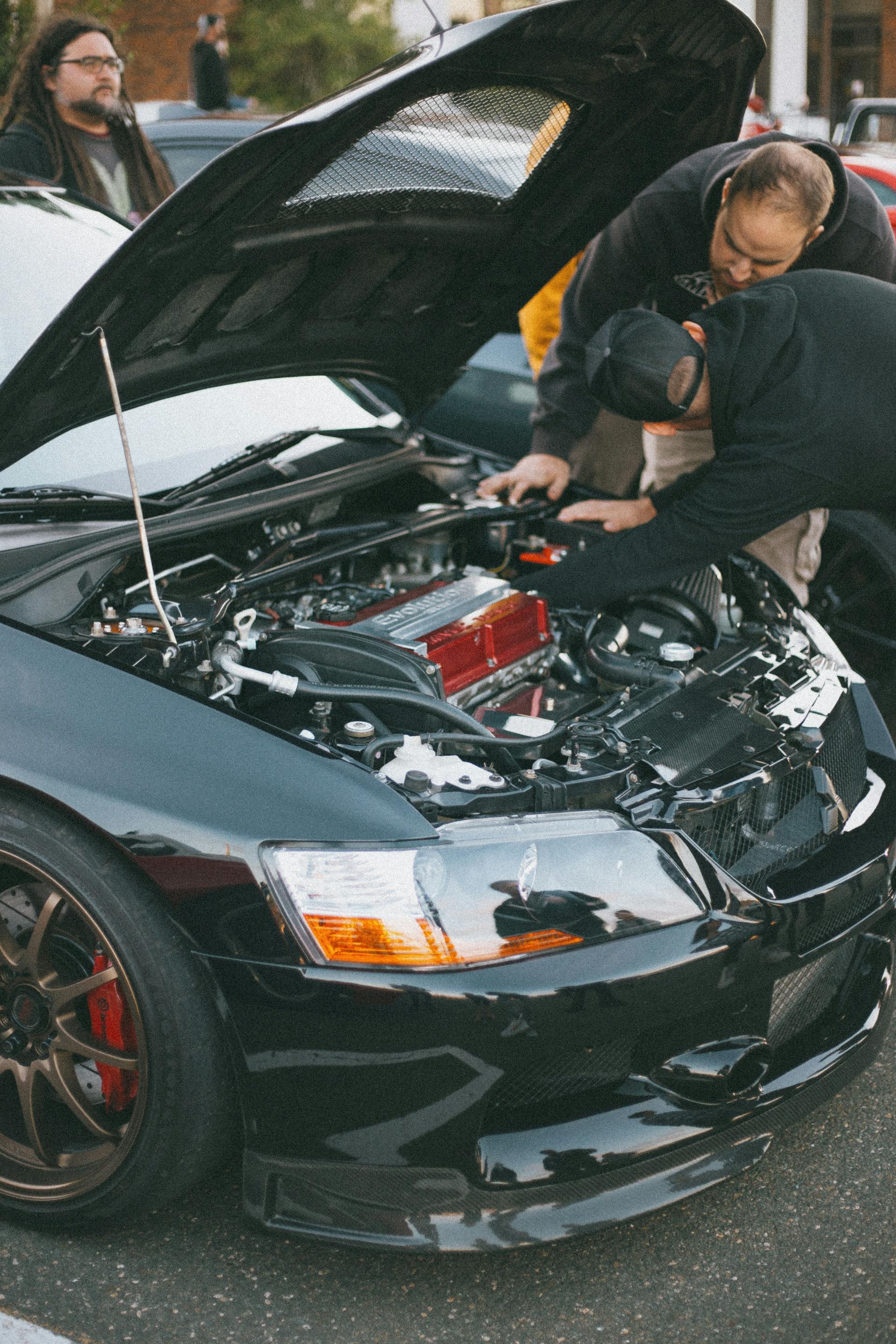 Mechanic inspecting used car engine outdoors before purchase in Oklahoma City